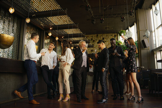 corporate businesspeople having fun and talking together in party