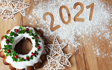 Christmas Stollen: a festive cake decorated with cranberries and twigs. Christmas decor on the table. Concept of greeting cards, banners, and holiday greetings. new year 2021