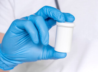 Doctor hand in sterile gloves holding jar with pills isolated on white background