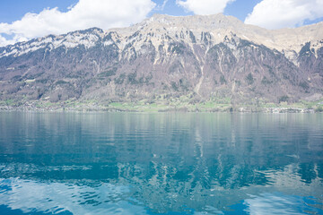 Beautiful lake in Swiss Alps in a sunny spring day with reflections in the lake water, bright colourful lake water