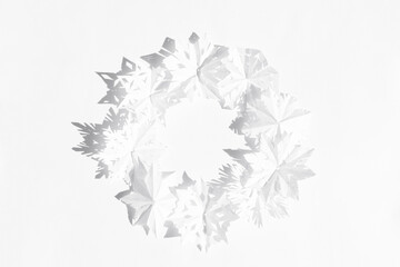 frame of paper cut snow flakes on a white background