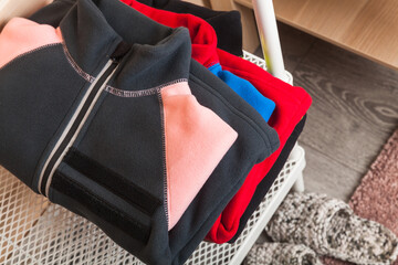 Stacked colorful fleece jackets laying on a shelf © evannovostro