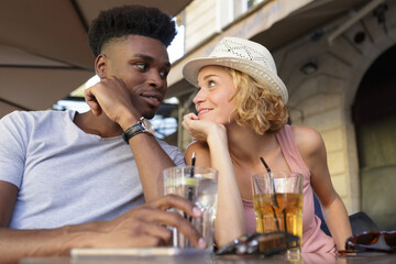 mixed couple enjoying a drink outdoors