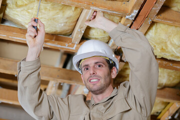 male builder working on ceiling joist