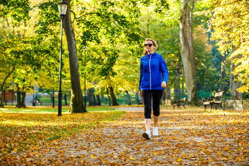 Middle-aged woman walking in city park
