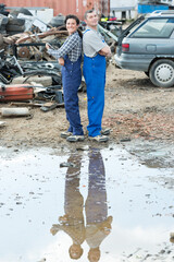 two metal workers in the scrap metal yard