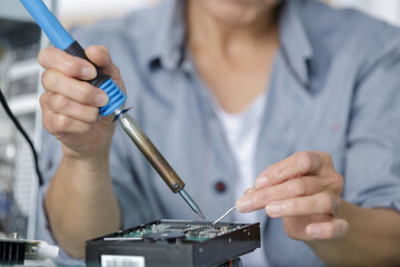 a woman soldering computer components