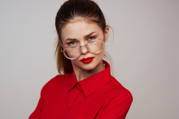 fashionable woman in a red shirt on a light background fun emotions bright makeup glasses attractive appearance 