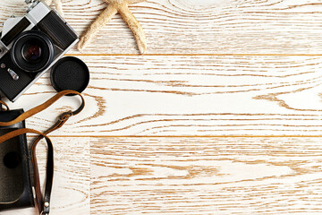 Vintage camera and retro travel accessories on the wooden surface. Flat lay template with copy space for text