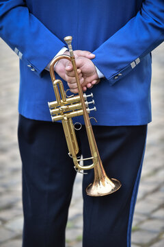 Military orchestra man performing during ceremony. Detail with musician holding his trumpet.