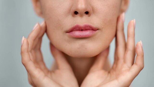 Extreme closeup feminine lips and chin applying anti aging cream on face skin. 4k Dragon RED camera