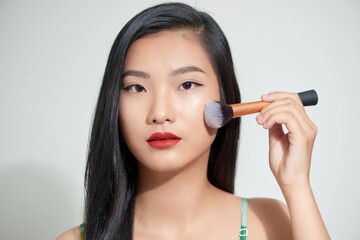 Obraz premium Beauty asian woman hold make up brush and cheerful with make up brush