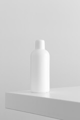 White cosmetic bottle mockup on a white table.