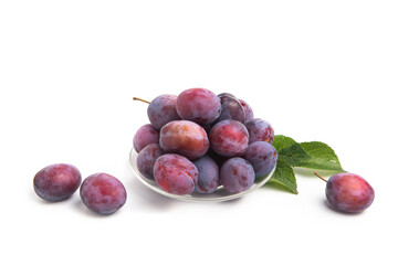 Fresh fruits. Blue plum fruit with leaves on a saucer on a white isolated background. Agricultural products.