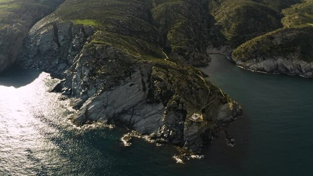Lighthouse on the edge of rocky shore of mediterranean sea coast, Cadaques, Spain