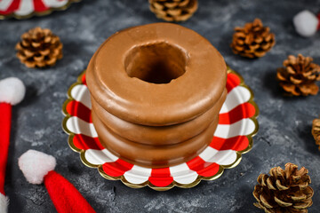 Traditional German layered winter cake called 'Baumkuchen' glazed with chocolate, surrounded by seasonal decoration