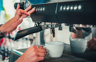 coffee machine is pourig coffee to white cup in bar