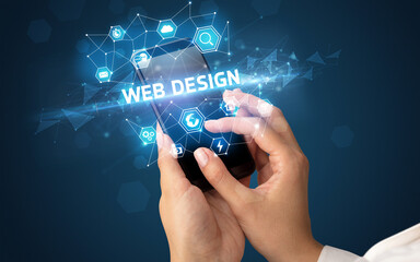 Female hand holding smartphone with WEB DESIGN inscription, modern technology concept