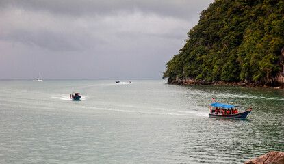 Fototapeta premium Boats riding over the beautiful sea surrounded by mountains