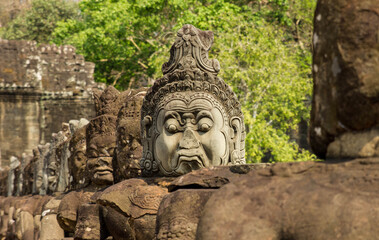 Ancient gatekeeper stone statue in front of the ruins of angkor wat