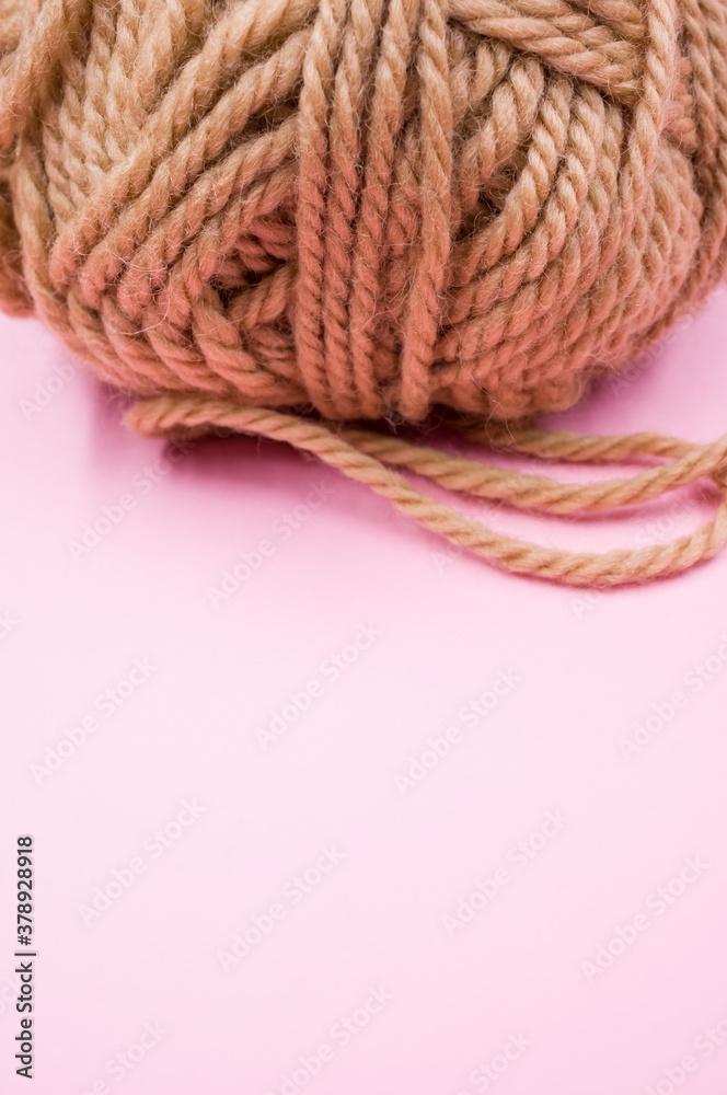 Canvas Prints Vertical shot of a ball of yarn on a pink surface