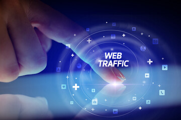 Finger touching tablet with social media icons and WEB TRAFFIC
