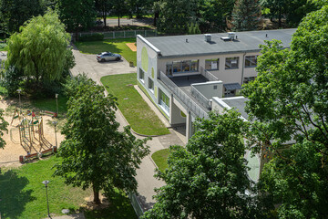 Fototapeta na wymiar Top view of yard of residential building. Modern exterior. City architecture. Playground. Sunny summer day.