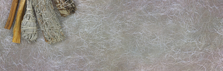 Four different smudge sticks background banner - rustic background with copy space for smudging text with white and blue sage, Yerba Sante and sage sticks in top left corner

