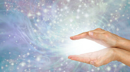Sending you magical high frequency healing energy - female cupped hands with magical white plasma...