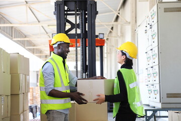 African American and Asian warehouse worker helping each other as teamwork to carry the product package to be ready for shipping