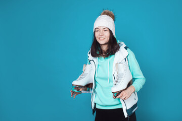 Winter hobby, ice skating. A young woman in a sweatshirt and a knitted hat
