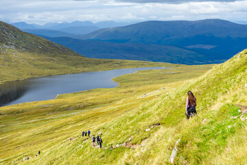 Hiking Ben Nevis, Scotland, UK with a scenic backdrop of mountains and a loch / lake