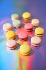 French cake macaron. Set of cute sweets on colorful rainbow background. almond cookies, pastel colors, top view