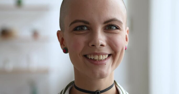 Dreamy young pretty bald woman wear choker earrings smile look at camera close up face. Stylish trendy female portrait. Healthy recovered after oncology disease girl start new fulfilling life concept