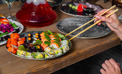 hand take sushi roll in plate on wooden table background