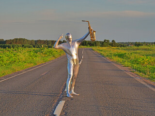 Man musician saxophonist in full body-hugging silver and silver electric suit holding golden alto...
