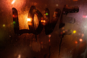 Love, a couple in love. Inscription on the fogged glass, night city