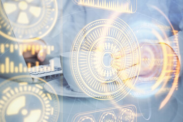 Technology theme hologram with man working on computer on background. High tech concept. Multi exposure.