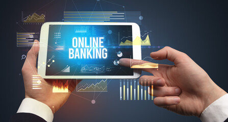 Close-up of hands holding tablet with ONLINE BANKING inscription, modern business concept