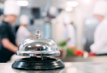 Table distribution in the restaurant. Cooks prepare food in the kitchen against the background of a...