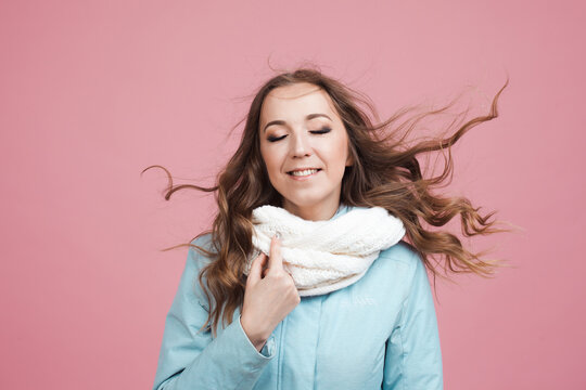 Nice Young Woman In A Blue Winter Jacket And Scarf, Her Hair In The Wind.