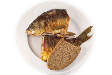 
Fried fresh fish and a slice of bread on a white plate.
