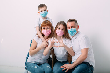 young family in medical masks during home quarantine.