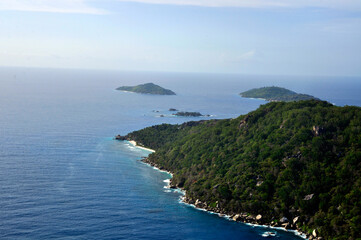 Aerial view of a tropical island with coastline and blue ocean. Félicité Island, La Digue, Seychelles