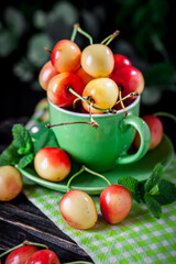 Fresh cherry in a Cup on a dark rustic wooden table. Background with space for copying. Selective focus.