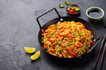Asian fried rice with egg and vegetables. Dark stone background. Copy space. Close up.
