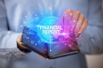 Businessman holding a foldable smartphone with FINANCIAL REPORT inscription, new business concept