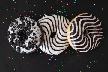 black and white donut close up on a black background. Top view. festive background.