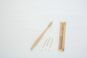 Bamboo Toothbrush, cotton bud and comb on white bed background. Environmental Protection, Zero waste, Reusable, Plastic free, World Environment day and Earth day concept
