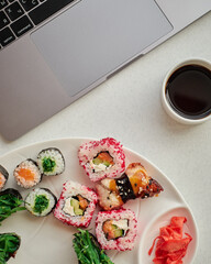 Food delivery. Tasty sushi rolls at workplace, closeup
